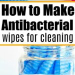 Scissors cut blue fabric; rolled blue cloths in a jar. Dive into the DIY world: How to Make Antibacterial Cleaning Wipes.