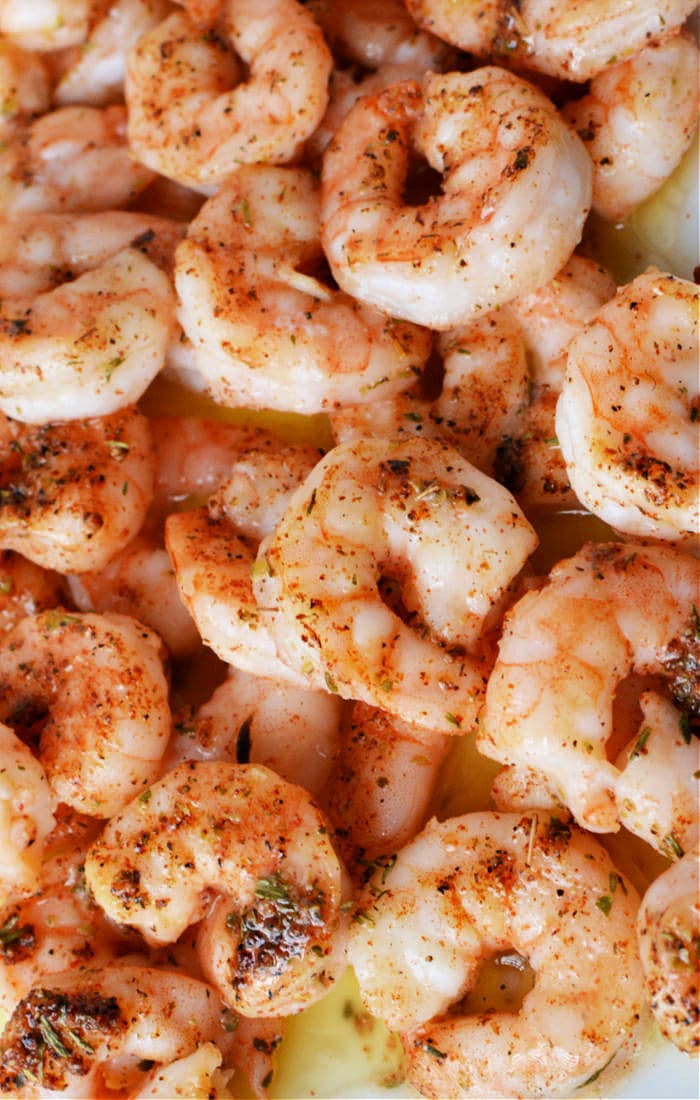 Discover the vibrant flavors of how to cook frozen raw shrimp, with each tender morsel seasoned perfectly with herbs and spices, captured in this close-up shot.